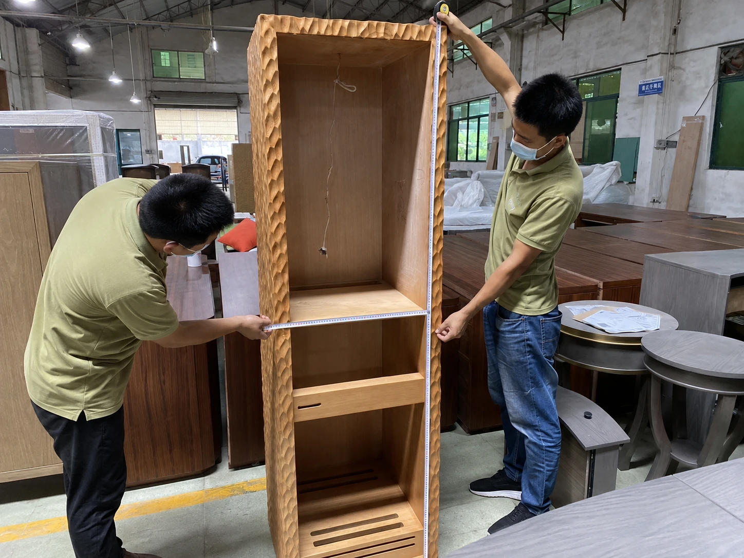 Factory worker measuring furniture dimensions